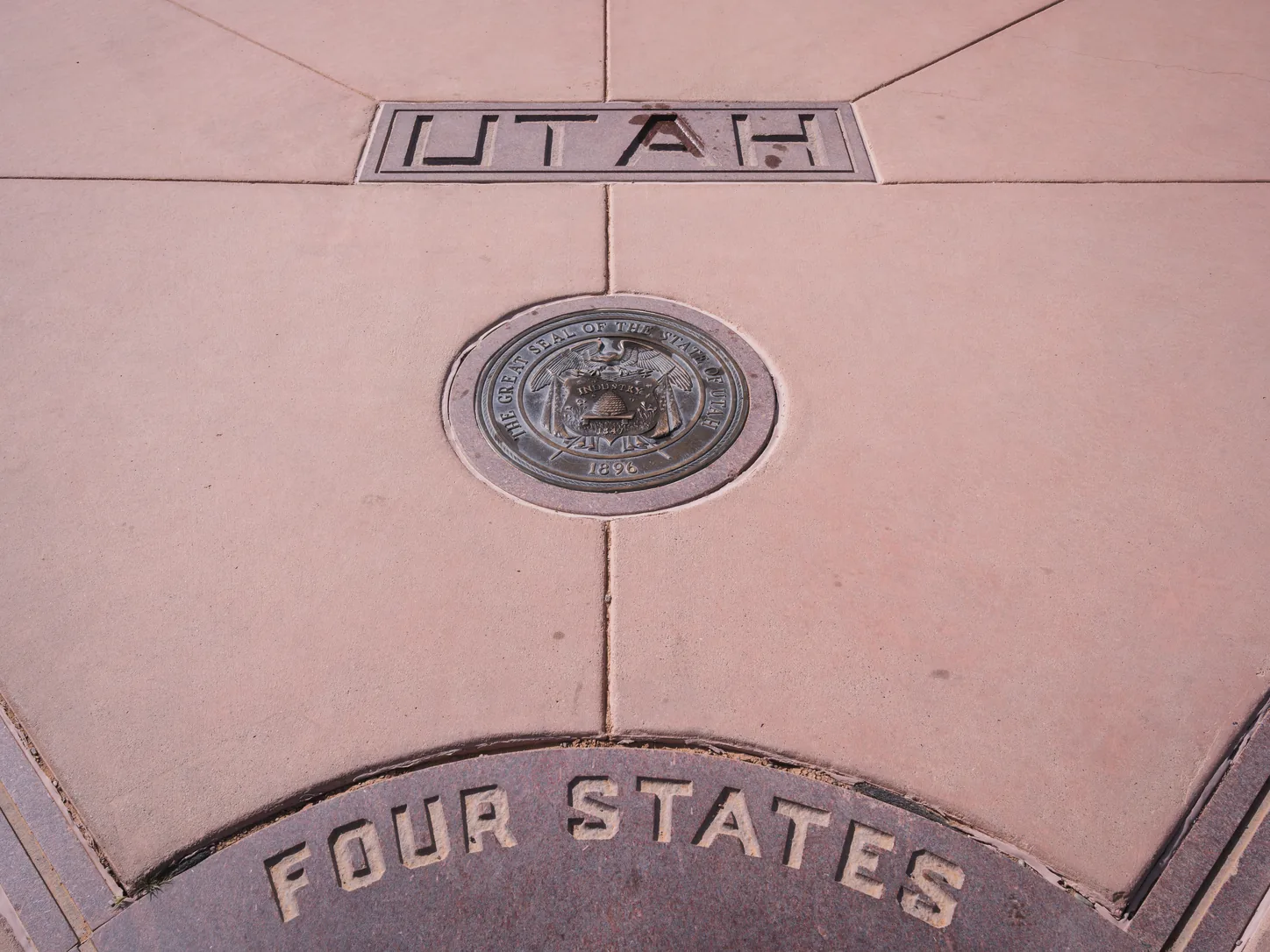 Un détail du dallage côté Utah : le mot UTAH gravé dans la pierre au-dessus du grand sceau en bronze de l’État de l’Utah, et en dessous les mots FOUR STATES gravés dans le segment du disque central